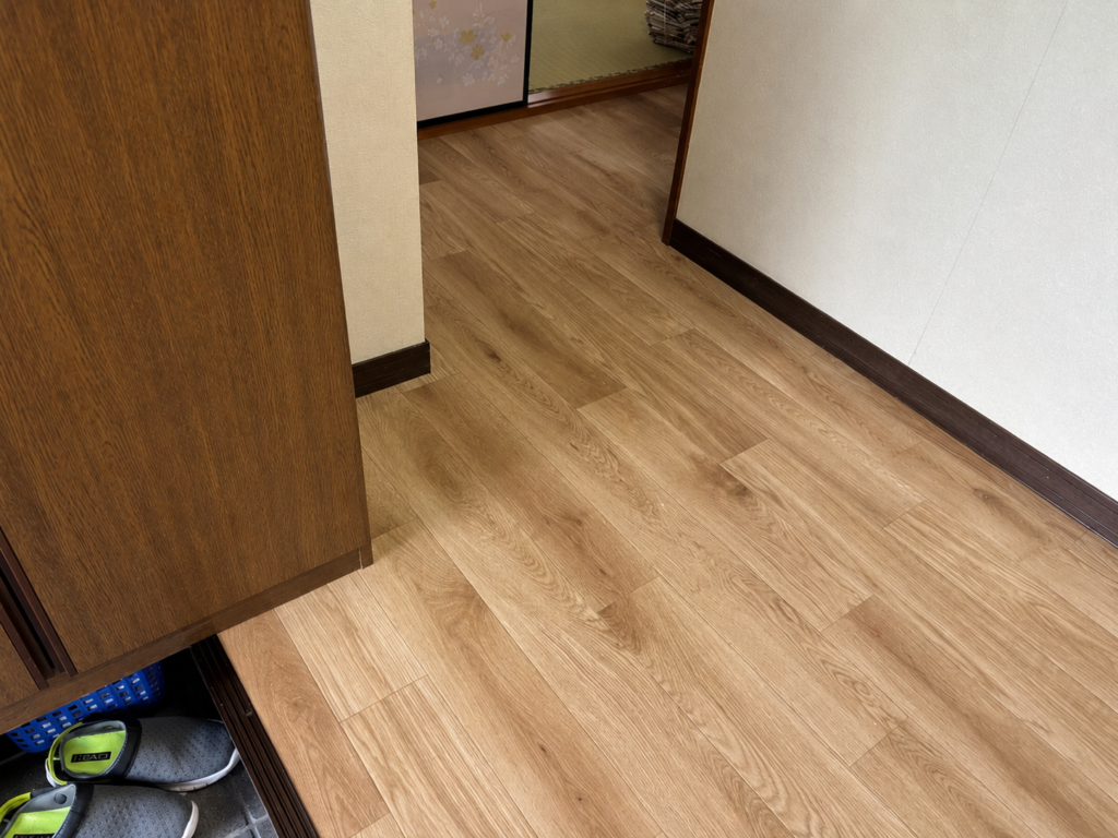 玄関床に新規貼りしたクッションフロア。木目調の柔らかな質感が空間に温かみを添える