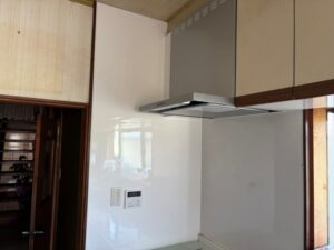 完成したレンジフード全体を斜め下から見た様子。シルバーの本体と白い壁面が調和し、キッチン空間が明るく清潔な印象に生まれ変わった