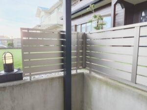 フェンスと手摺の組み合わせを近くから見た様子。グレーのフェンスパネルと手摺が一体となり、目隠しと安全性を同時に確保しています。