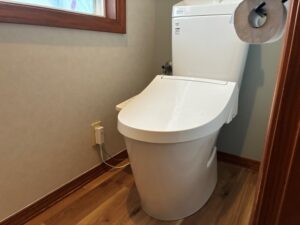 完成したトイレ全景。LIXIL アメージュ便器と木目調の床、塗り壁調の壁が調和し、すっきりとした空間に生まれ変わりました